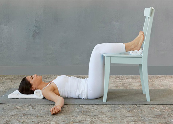 Yoga chữa mất ngủ với tư thế gác chân lên ghế